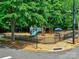 Community playground with swings, slide, climbing structure, picnic table, and seating in a fenced area at 6541 Hasley Woods Dr, Huntersville, NC 28078