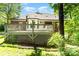 Back of the house with a deck overlooking a manicured lawn and mature trees, offering a private retreat at 7587 Long Valley Dr, Harrisburg, NC 28075