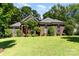 Charming brick home with well-manicured lawn, mature trees, and inviting curb appeal at 7587 Long Valley Dr, Harrisburg, NC 28075