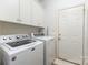 Laundry room with front load washer and dryer and storage cabinets at 7587 Long Valley Dr, Harrisburg, NC 28075