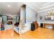 Open-concept living room with staircase, hardwood floors, fireplace, and stylish blue accent wall at 7587 Long Valley Dr, Harrisburg, NC 28075