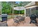 Cozy back deck area featuring a grill, patio seating, and serene wooded views for outdoor living at 7687 Bermuda Hills Ln, Denver, NC 28037