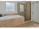 Bathroom featuring soaking tub with tile surround, a glass shower, tile flooring, and natural light at 7687 Bermuda Hills Ln, Denver, NC 28037