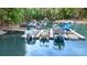 Close-up view of multiple covered boats docked at a marina on a serene lake in a wooded waterfront community at 7687 Bermuda Hills Ln, Denver, NC 28037