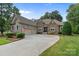 Charming stone-accented home features a three-car garage and manicured landscaping at 7687 Bermuda Hills Ln, Denver, NC 28037