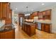 Open kitchen with island, stainless appliances, wooden cabinets and eat-in dining nook at 7687 Bermuda Hills Ln, Denver, NC 28037