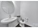 Charming half bathroom with pedestal sink and modern fixtures adding a touch of elegance to the space at 9029 Woodview Ct, Fort Mill, SC 29707