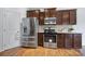 Modern kitchen with stainless steel appliances, dark wood cabinetry, and a tiled backsplash for a touch of style at 9029 Woodview Ct, Fort Mill, SC 29707