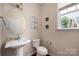 Cozy half-bath with a pedestal sink, a toilet, and decorations, adding to the comfort of the room at 9159 Marasol Ln, Concord, NC 28027