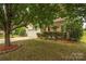 Beautifully landscaped front yard with mature trees and a charming two-story home at 9159 Marasol Ln, Concord, NC 28027
