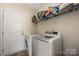 Functional laundry room with a side-by-side washer and dryer and plenty of storage above, adding practicality at 9159 Marasol Ln, Concord, NC 28027