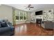 Cozy living room with a fireplace, built-in shelves, hardwood floors, and large windows at 9159 Marasol Ln, Concord, NC 28027