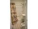 Bathroom with a combined tub and shower, pedestal sink, and decorative floral shower curtain at 925 Grace Ave, Lancaster, SC 29720