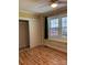Bedroom with laminate floor, a window, built-in shelves, and a closet at 925 Grace Ave, Lancaster, SC 29720