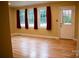 Living room featuring hardwood floors and natural light with red drapes at 925 Grace Ave, Lancaster, SC 29720