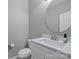 Stylish bathroom with white vanity, stone countertop and a round mirror at 9321 Bradstreet Commons Way, Charlotte, NC 28215