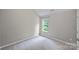 A bright bedroom with neutral walls, plush carpeting, and a window with views of the outdoors at 9321 Bradstreet Commons Way, Charlotte, NC 28215