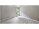 Bright bedroom with neutral walls, carpet, and a window providing views of greenery at 9321 Bradstreet Commons Way, Charlotte, NC 28215