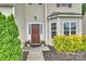 Inviting front entrance with a dark brown door, manicured landscaping, and ample natural light at 9321 Bradstreet Commons Way, Charlotte, NC 28215