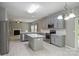 Modern kitchen with island, stainless steel appliances, gray cabinets, and open view into living area at 9321 Bradstreet Commons Way, Charlotte, NC 28215