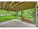 Covered patio featuring wooden beams, string lights, stacked firewood, and backyard views at 9321 Bradstreet Commons Way, Charlotte, NC 28215