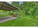 Covered patio with an outdoor area, lush landscaping, and a pile of wood at 9321 Bradstreet Commons Way, Charlotte, NC 28215