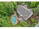 Breathtaking aerial view of a home with an in-ground swimming pool, lush landscaping, and stone patio at 9624 Barnburgh Ln, Huntersville, NC 28078