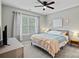 Comfortable bedroom features a bed with blue bedding, natural lighting, and a ceiling fan for optimal comfort at 9624 Barnburgh Ln, Huntersville, NC 28078