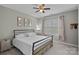 Cozy bedroom featuring carpeted floors, a ceiling fan, and a comfortable bed with soft, white bedding at 9624 Barnburgh Ln, Huntersville, NC 28078