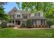 Charming two-story brick home with manicured lawn, decorative shutters, and inviting front porch at 9624 Barnburgh Ln, Huntersville, NC 28078