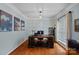 Well-lit home office with hardwood floors, decorative wallpaper, and a large executive desk at 9624 Barnburgh Ln, Huntersville, NC 28078