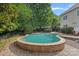 Serene pool surrounded by lush landscaping and a brick patio, creating a private backyard retreat at 9624 Barnburgh Ln, Huntersville, NC 28078