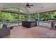 Relaxing screened porch with hot tub, seating, and serene backyard view at 9624 Barnburgh Ln, Huntersville, NC 28078