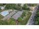 The aerial view shows the tennis courts and community pool near a road with mature trees at 108 Pier 33 Dr # 414, Mooresville, NC 28117