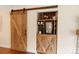 Custom bar with wine fridge and storage behind wooden barn-style doors at 108 Pier 33 Dr # 414, Mooresville, NC 28117