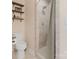 Tiled shower stall and toilet, enhanced by floating shelves with decor and a neutral palette at 108 Pier 33 Dr # 414, Mooresville, NC 28117