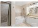 Well-lit bathroom with a tiled shower, soaking tub, granite countertop vanity, and decorative accents at 108 Pier 33 Dr # 414, Mooresville, NC 28117