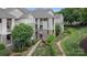 Exterior shot of a multi-story home with a walkway, manicured lawn and mature trees at 108 Pier 33 Dr # 414, Mooresville, NC 28117