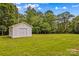 Backyard featuring a storage shed, lots of green grass, and a clothes line at 115 Three Oaks Ln, Statesville, NC 28677