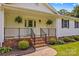 Close up of the front porch with black railings and two hanging ferns at 115 Three Oaks Ln, Statesville, NC 28677