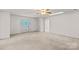 Open living room with large front entry door, ceiling fan, and neutral carpet and paint at 115 Three Oaks Ln, Statesville, NC 28677