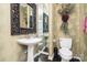 Elegant bathroom featuring a pedestal sink, decorative mirror, and ornate wallpaper at 118 Sunrise Cir, Mooresville, NC 28117