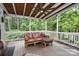 Covered wooden deck showcases floral cushioned outdoor seating with wooded backyard at 118 Sunrise Cir, Mooresville, NC 28117