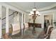 Bright dining area with chandelier, leading to the staircase, columns, and front door entrance at 118 Sunrise Cir, Mooresville, NC 28117