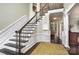 Elegant foyer features a staircase with dark wood railings, complemented by white wainscoting and hardwood flooring at 118 Sunrise Cir, Mooresville, NC 28117
