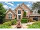 Charming brick home featuring a meticulously landscaped front yard with lush bushes, blooming flowers, and a charming water fountain at 118 Sunrise Cir, Mooresville, NC 28117