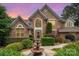 Inviting brick home featuring a meticulously landscaped front yard with lush bushes, blooming flowers, and a charming water fountain at 118 Sunrise Cir, Mooresville, NC 28117