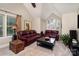 Cozy living room featuring vaulted ceiling, leather furniture, and a large window at 118 Sunrise Cir, Mooresville, NC 28117