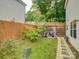 Fenced backyard with small patio and stone pathway surrounded by green grass and trees at 1209 Gaston Ave, Gastonia, NC 28052