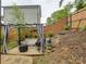 Backyard patio area with curtains, stone pavers, outdoor seating, and tiered landscape at 1209 Gaston Ave, Gastonia, NC 28052